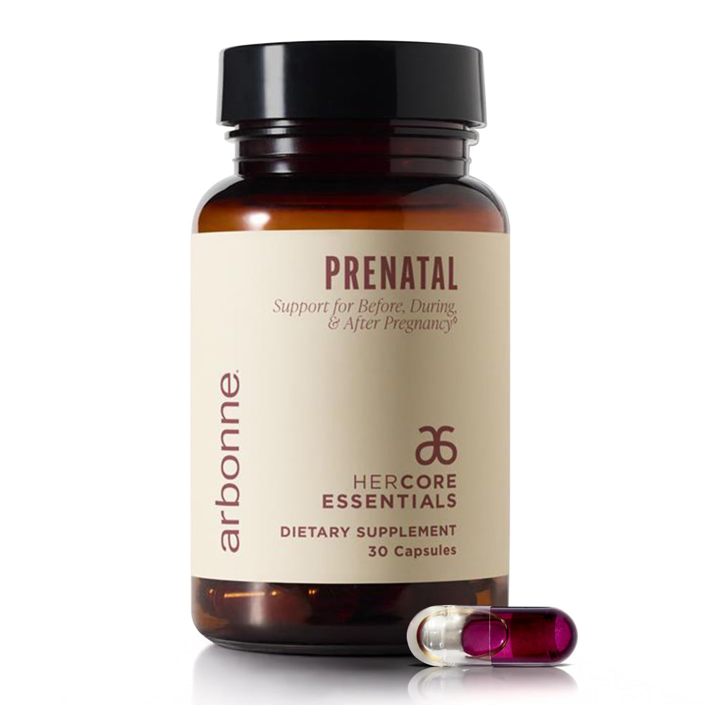 Arbonne HerCore Essentials Prenatal bottle on a clean counter with vegan DHA and folate nutrients.