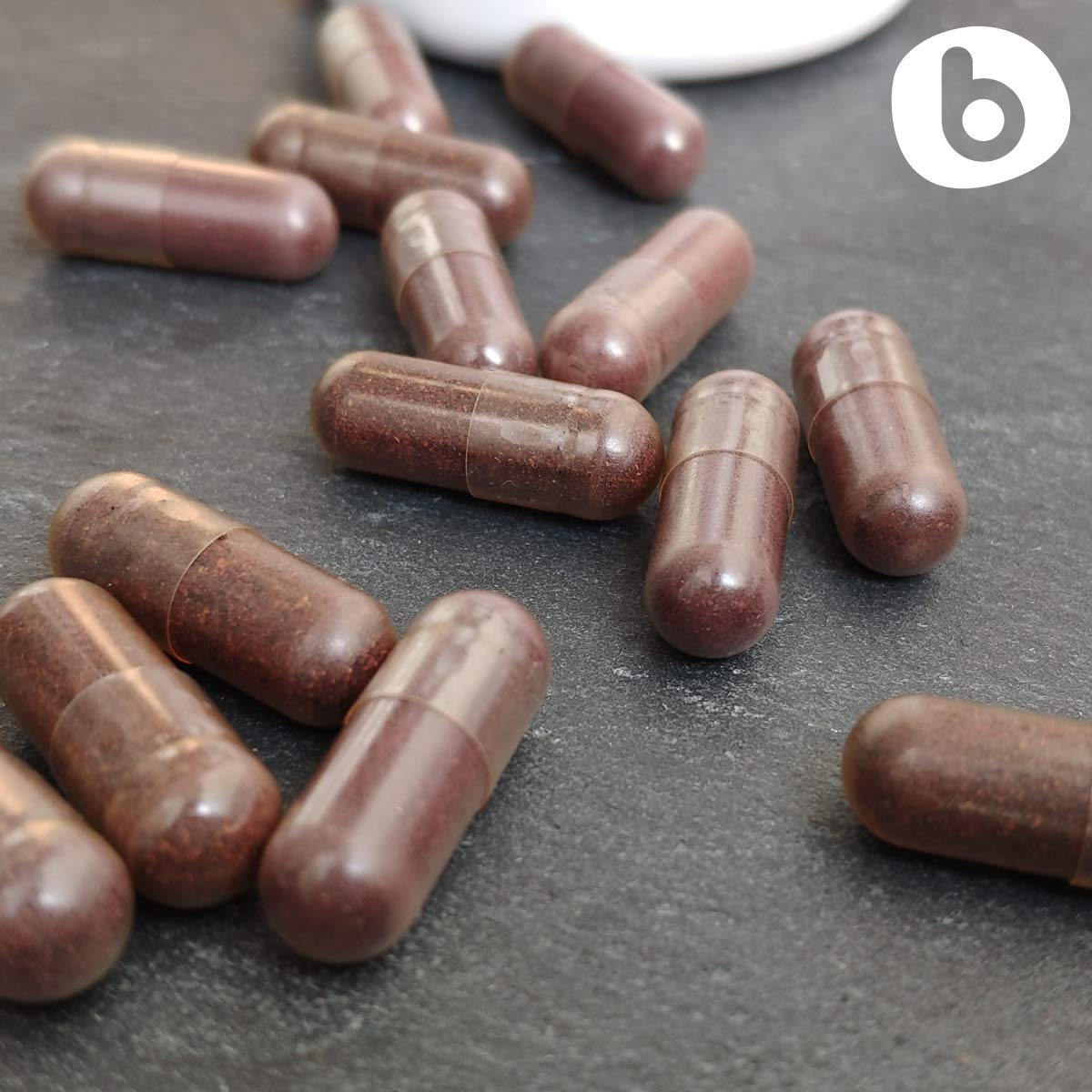 b Organic Aronia Berry Capsules closeup of powder inside capsules indicating natural plant powder