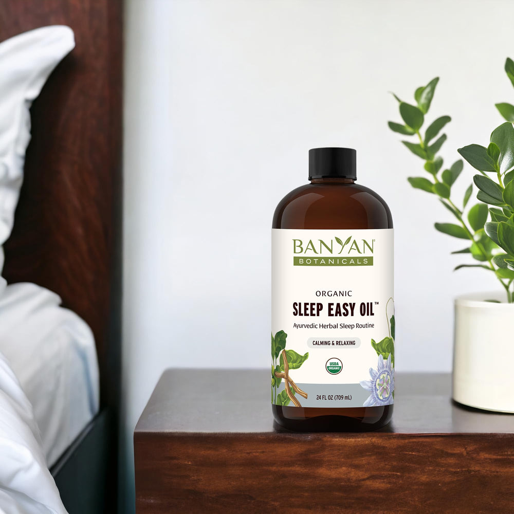 Sleep Easy Oil with ashwagandha and chamomile beside the bottle, highlighting natural ingredients