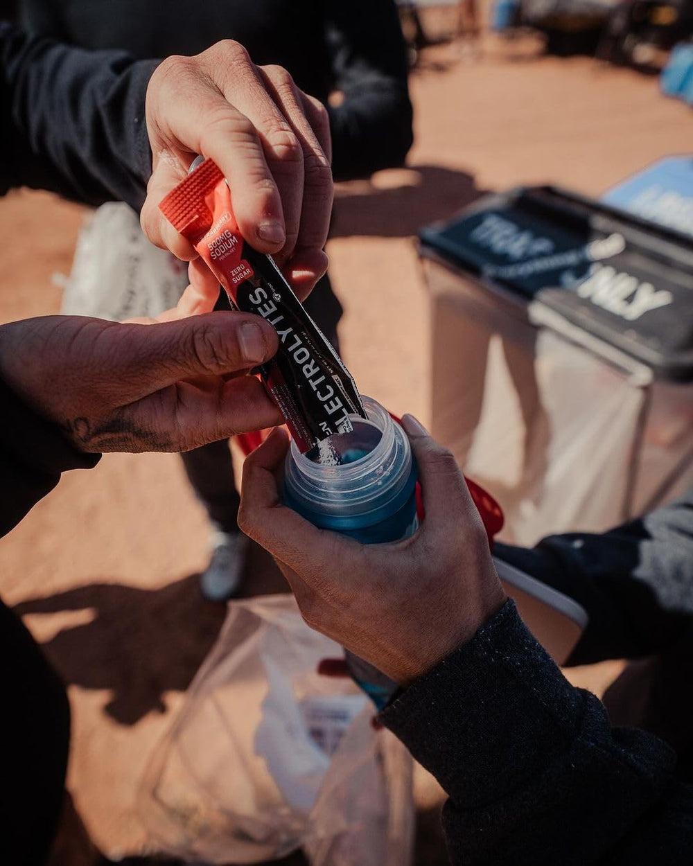 On-the-go athlete mixing BPN Electrolytes during travel or training with strawberry flavor.