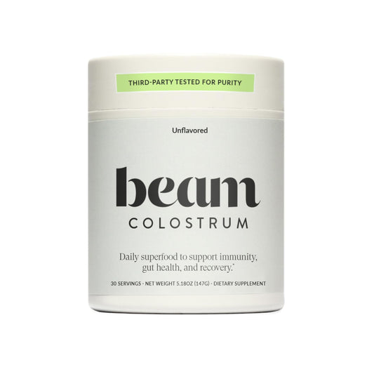 Beam Colostrum Powder jar pour: grass-fed formula supports gut health and daily wellness.