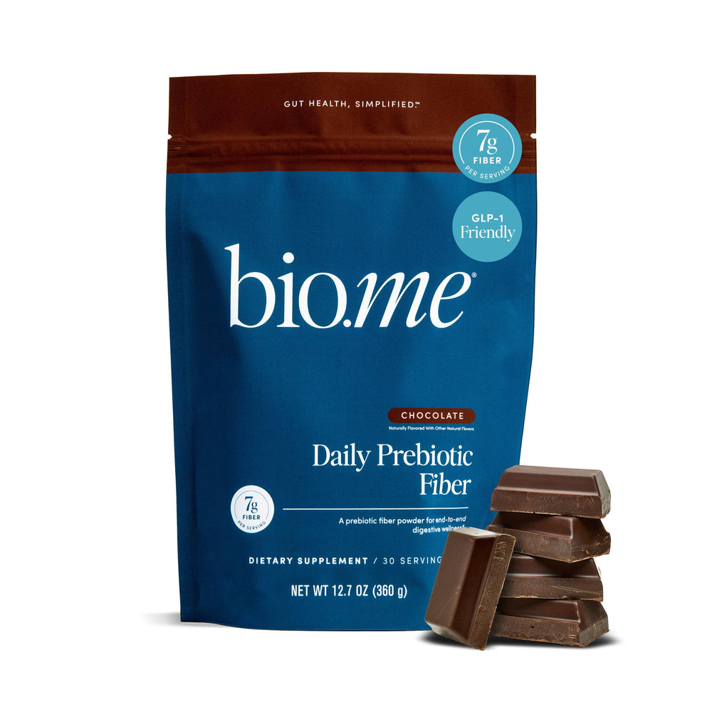 Bio.me daily prebiotic fiber powder chocolate bottle on kitchen counter supports daily digestion.