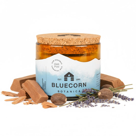Bluecorn Beeswax 3-Wick Candle in amber glass emits warm glow for living rooms.