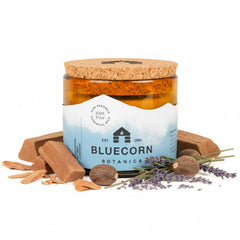 Bluecorn Beeswax 3-Wick Candle in amber glass emits warm glow for living rooms.