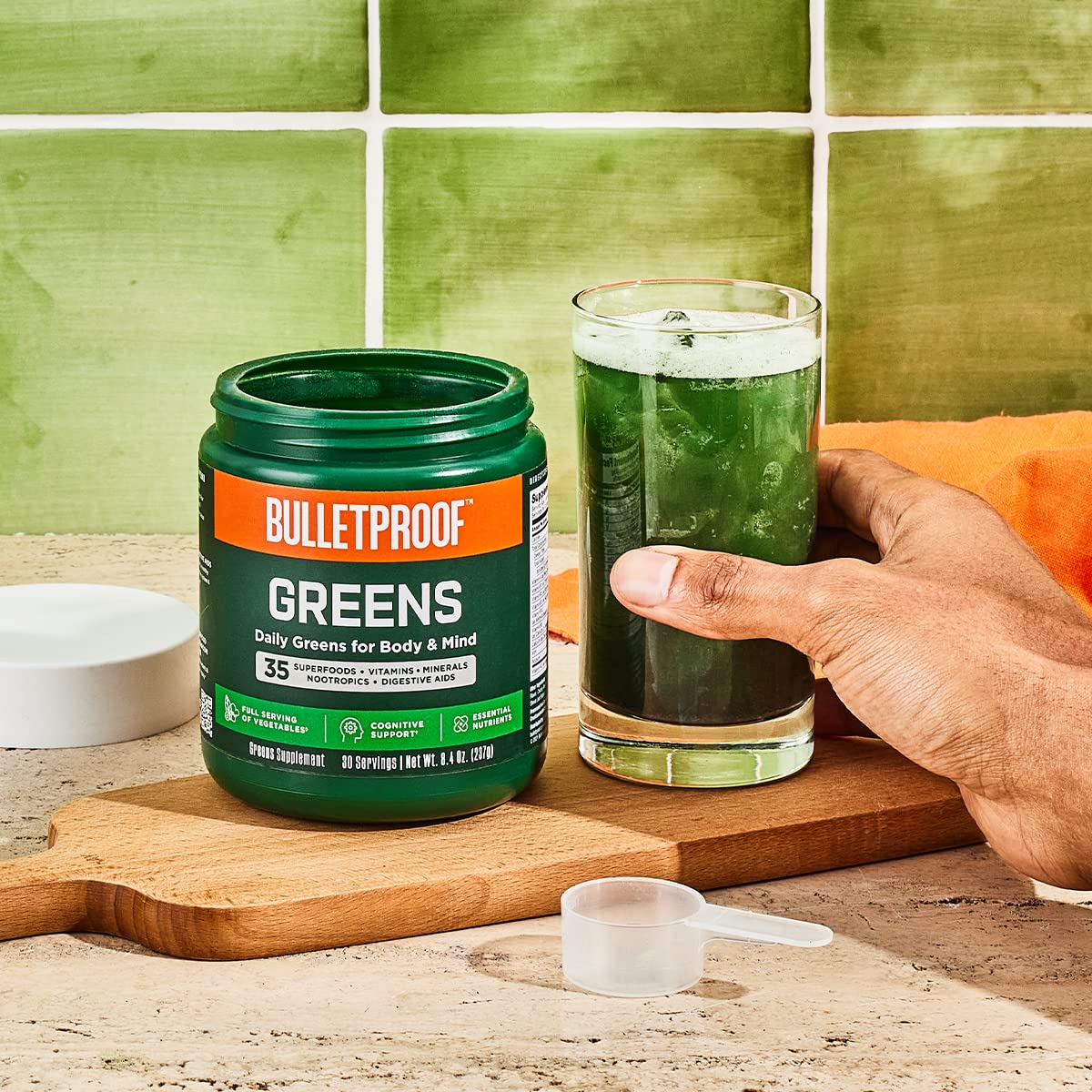Bulletproof Greens glass with water highlighting pineapple-flavored blend