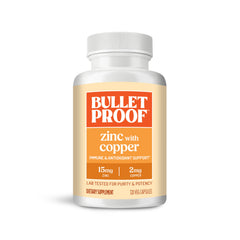 Bulletproof Zinc with Copper capsules beside a glass of water for daily immune support