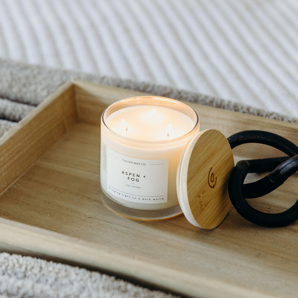 Wooden lid beside the glass jar of Aspen & Fog candle.