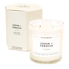 Calyan Wax Co Cedar & Tobacco 2-wick candle glowing in a cozy living room
