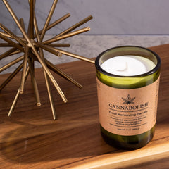Cannabolish candle lit in a living room setup for room-wide scent management.