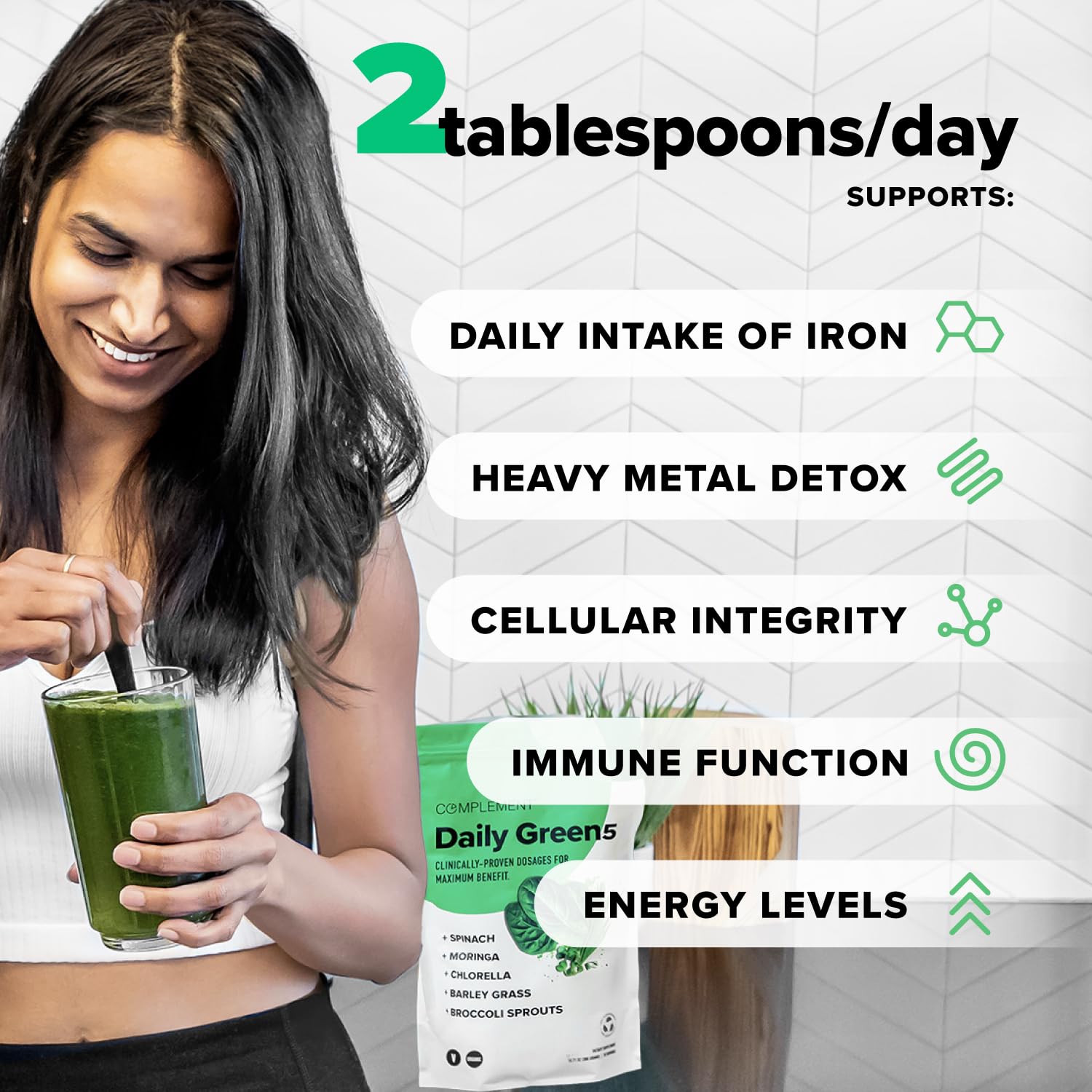 Complement Daily Greens Powder scoop beside glass for an energy boost
