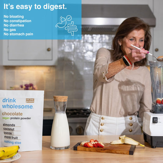 Drink Wholesome vegan protein powder scoop beside jar, showcasing a clean ingredient list for digestion.