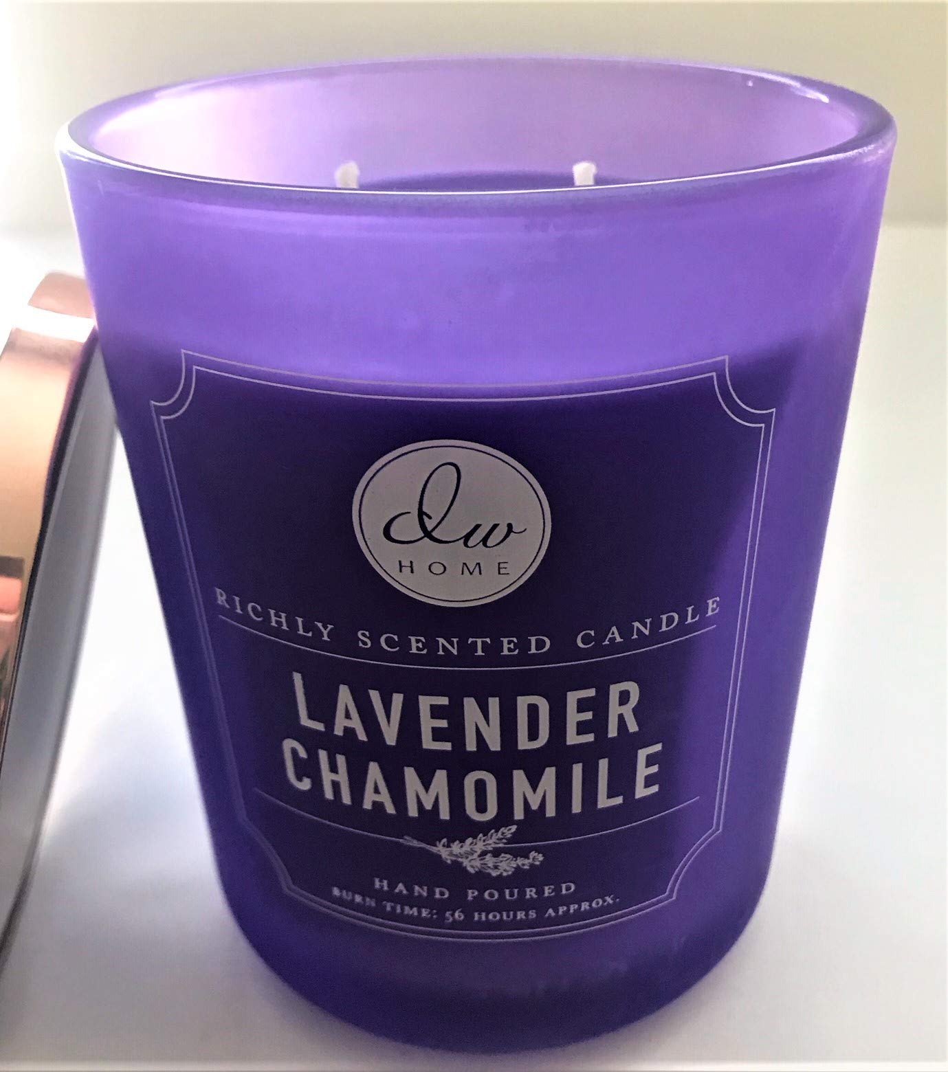 DW Home lavender chamomile candle on table enhancing relaxing ambience with bergamot notes.