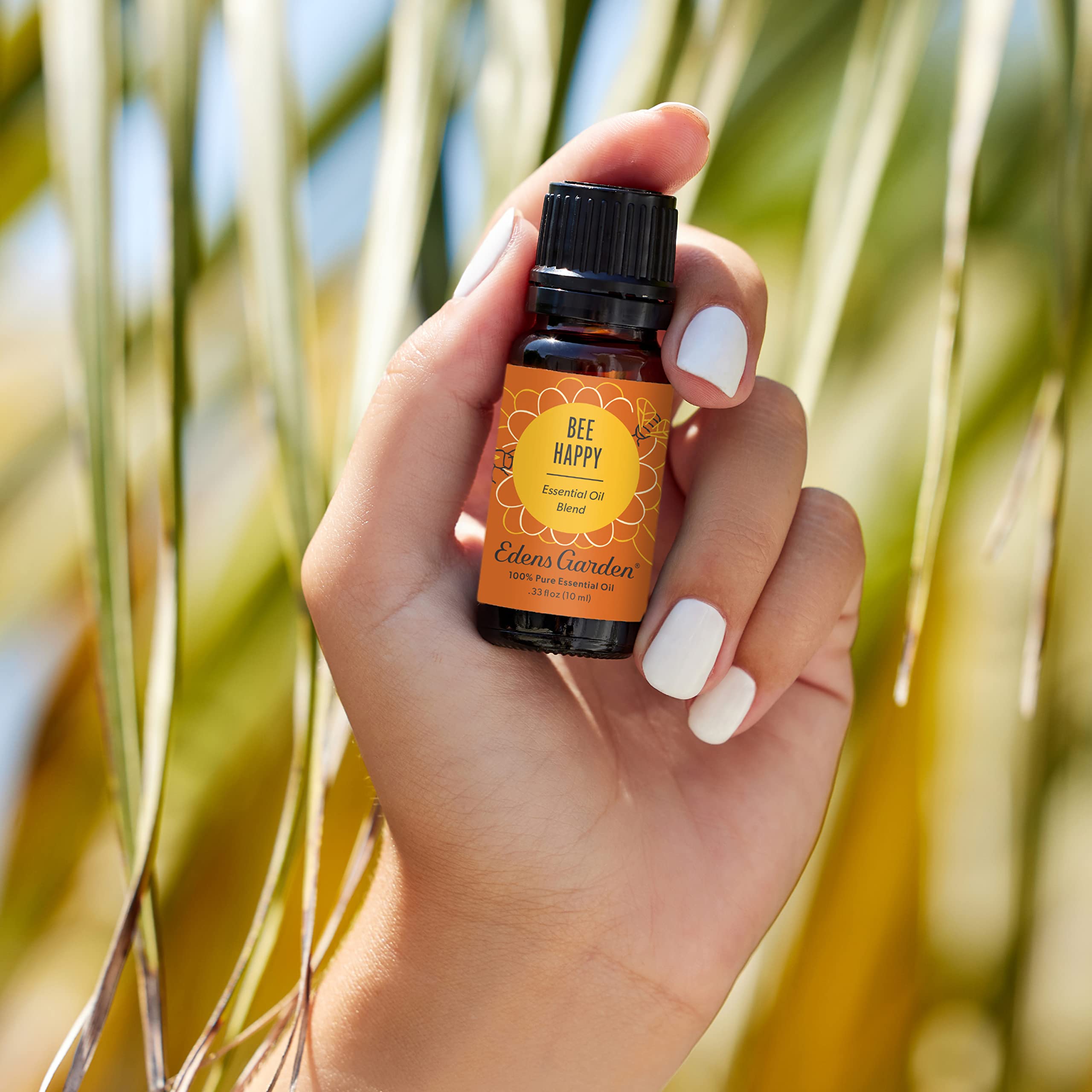 Bee Happy essential oil bottle with dropper releasing citrus aroma.