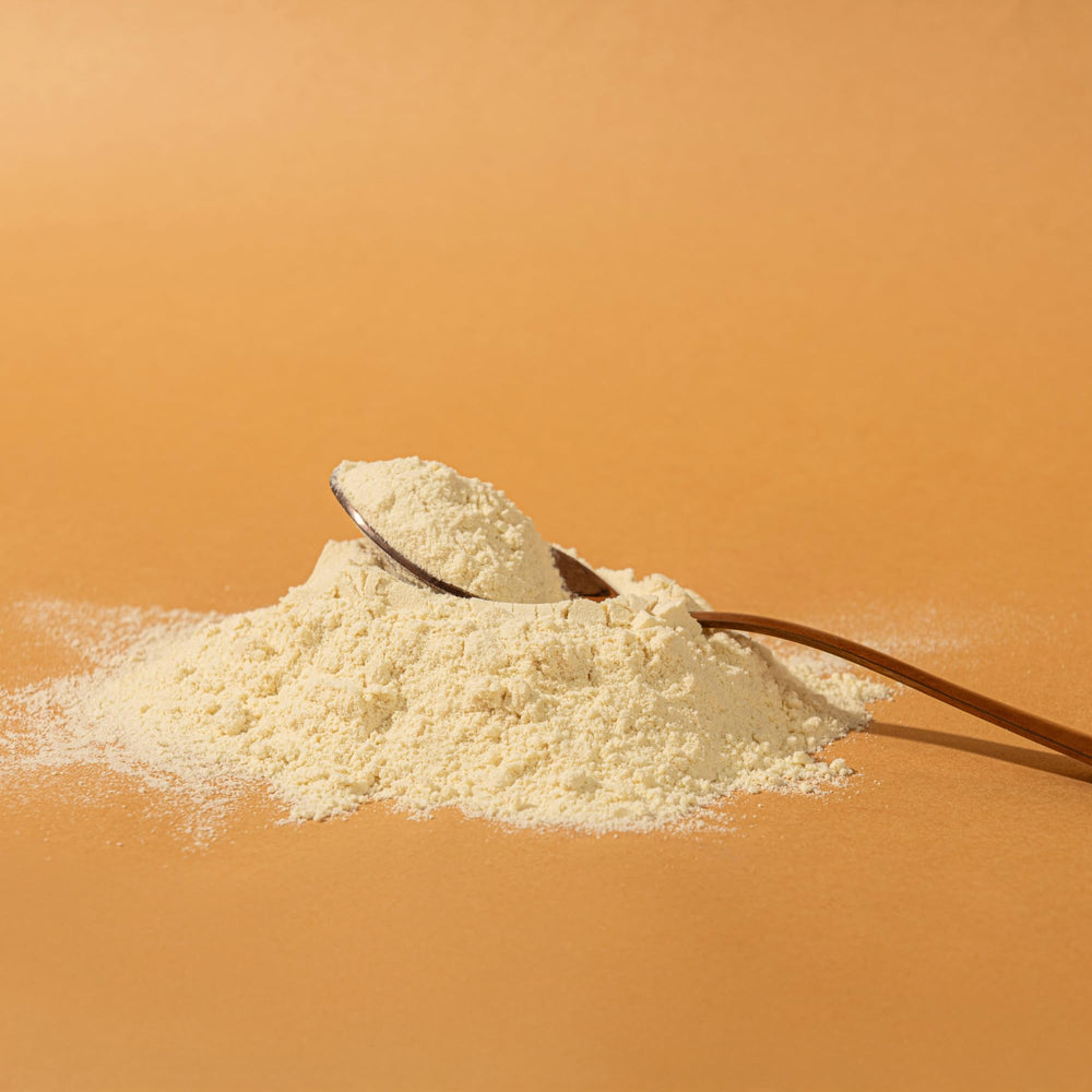 Pouring Elements Vanilla protein powder into a shake for smooth digestion and flavor