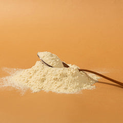 Pouring Elements Vanilla protein powder into a shake for smooth digestion and flavor
