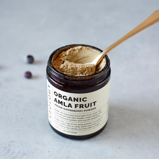 Amla powder scoop showing texture, ideal for smoothies and warm beverages.