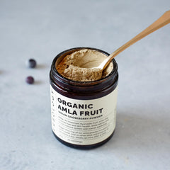 Amla powder scoop showing texture, ideal for smoothies and warm beverages.
