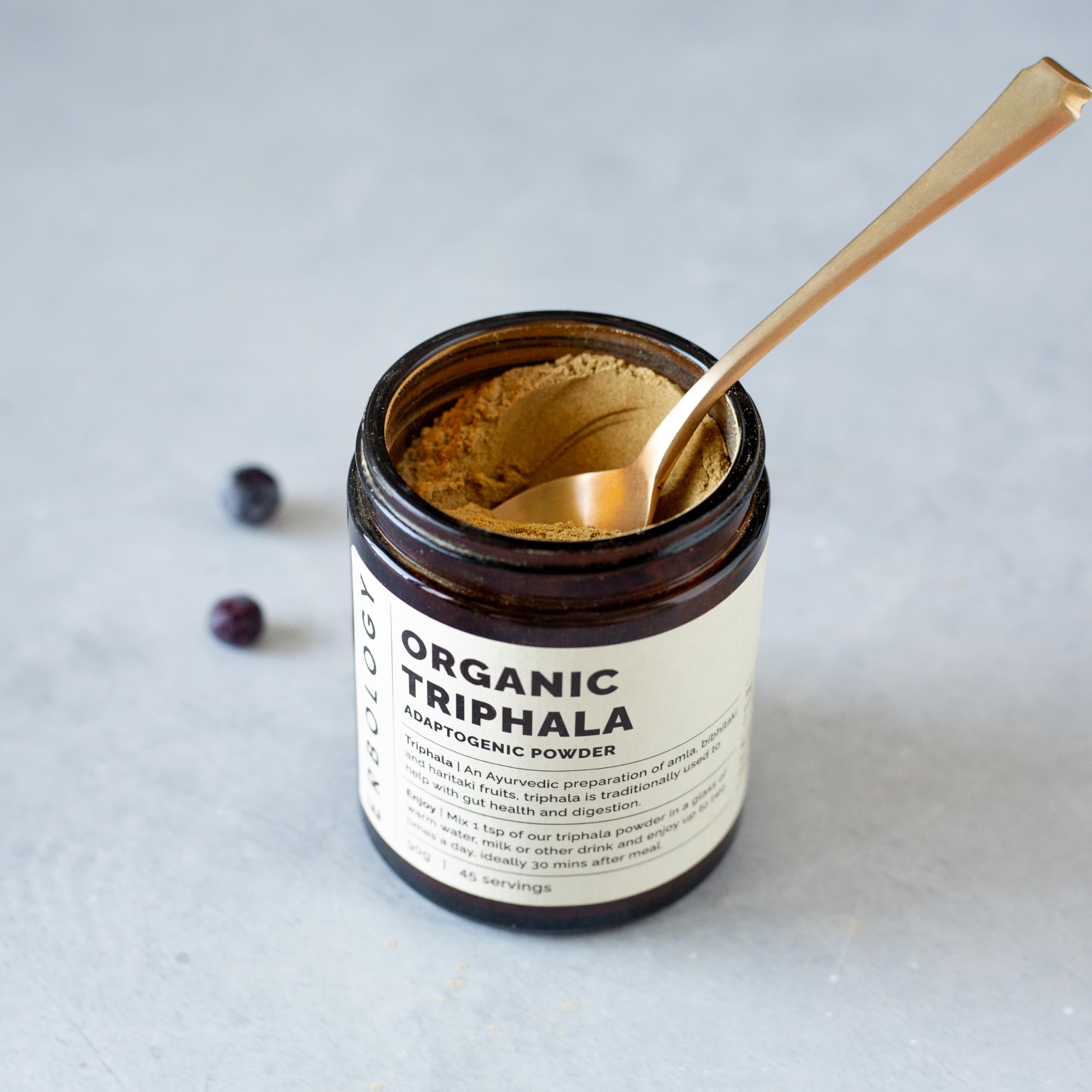 Erbology Triphala powder spoon shows easy mixing into warm beverages.