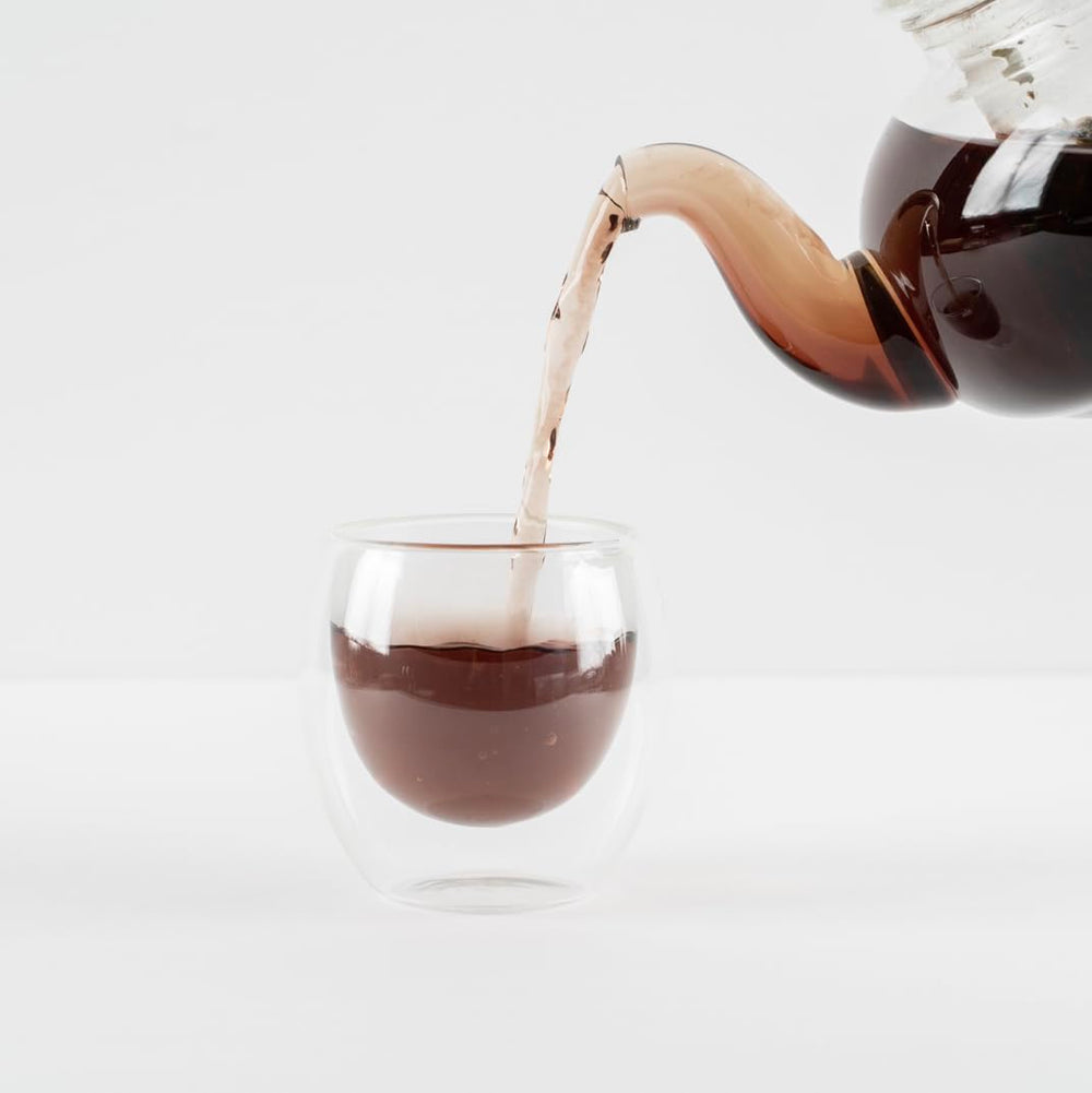 Food Over Drugs detox tea brewed in glass cup suggests a soothing daily ritual.