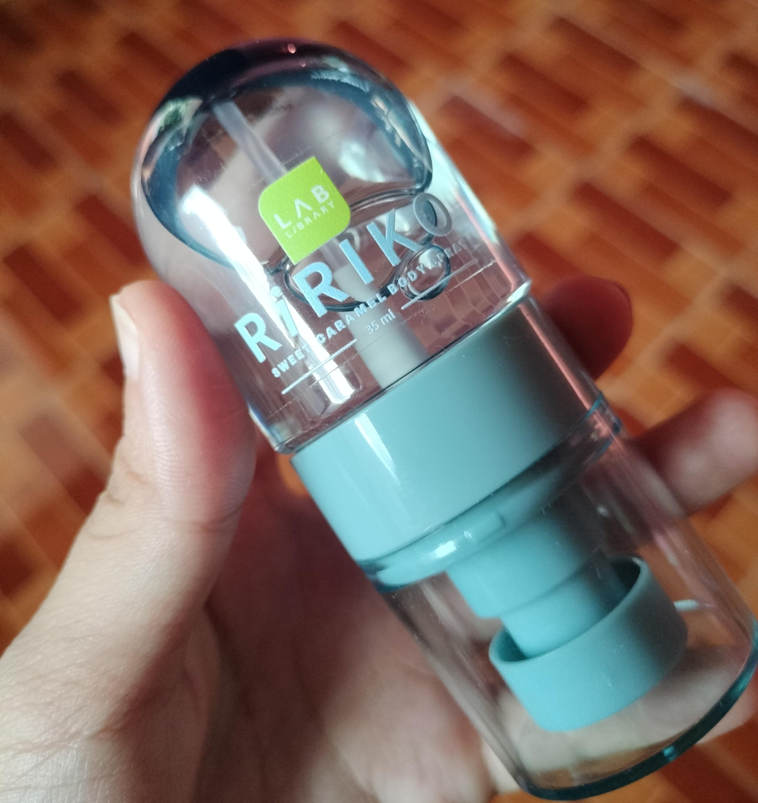 Travel-size Ririko Sweet Caramel Body Mist held in hand