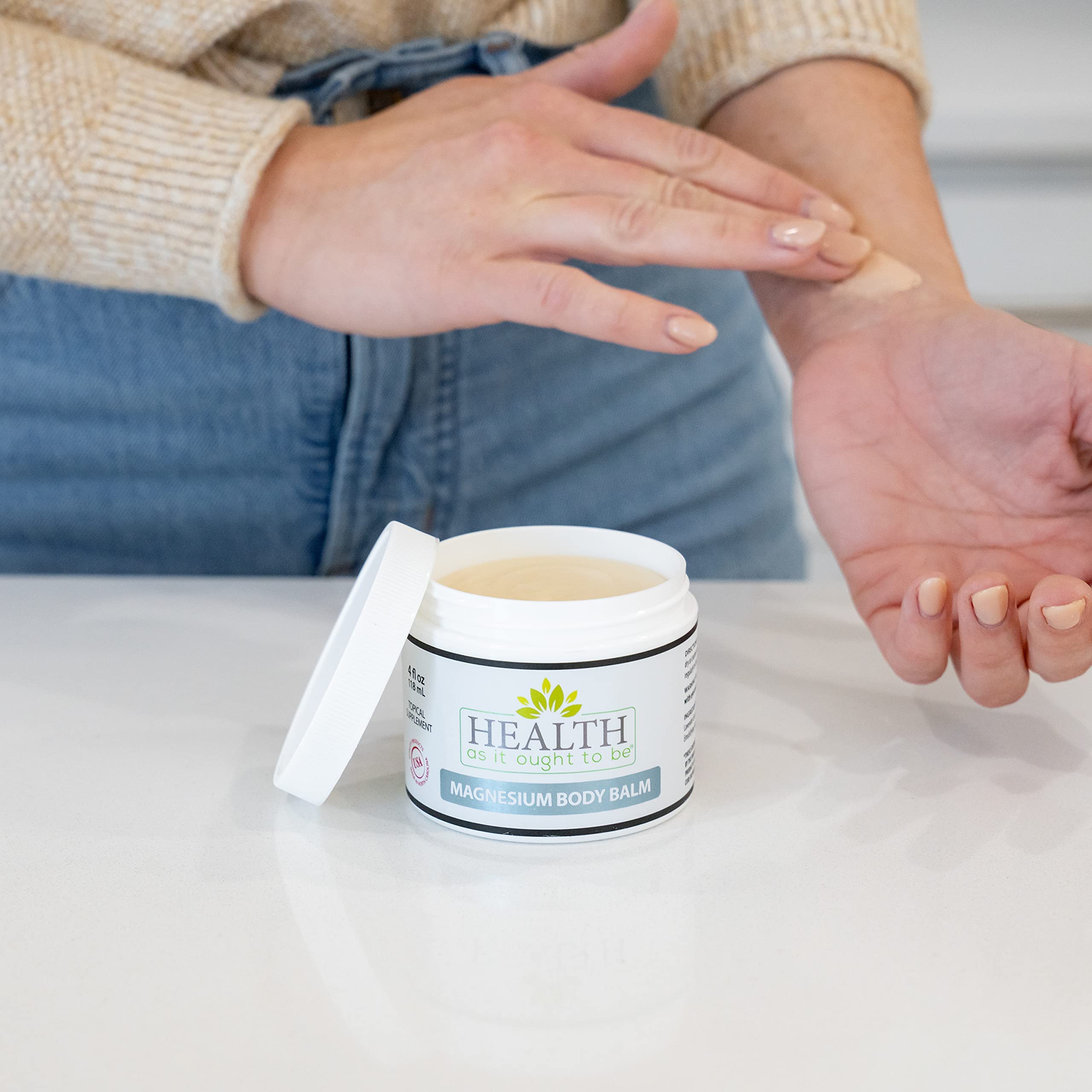 Health As It Ought To Be magnesium body balm jojoba coconut oil close-up shows creamy, hydrating formula.