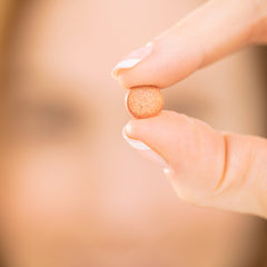 Capsules with soft-focus skin background suggesting smoother skin texture