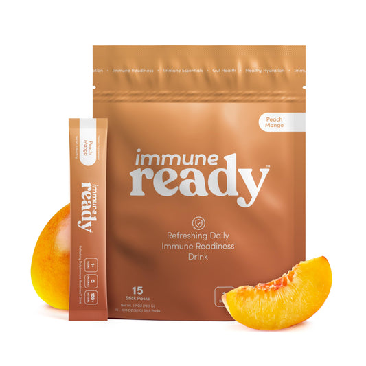 Immune Ready electrolyte packet Peach Mango in a glass for refreshing hydration.