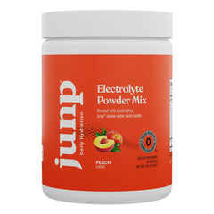 Scoop of JUNP Peach electrolyte powder beside a shaker for post-workout hydration.