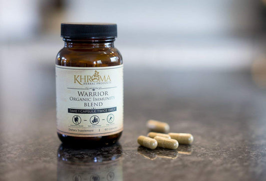 Khroma Warrior herbal capsules on a wooden surface, promoting natural immune support.