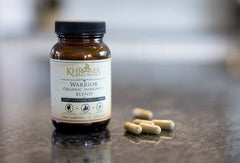 Khroma Warrior herbal capsules on a wooden surface, promoting natural immune support.