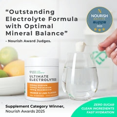Love Life Electrolytes glass pour shows a refreshing orange-lime drink.
