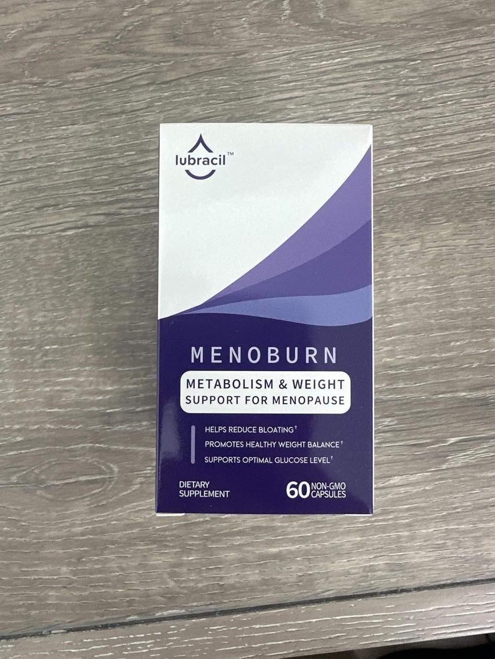 Glass of water beside Lubracil Menoburn capsules for easy daily consumption