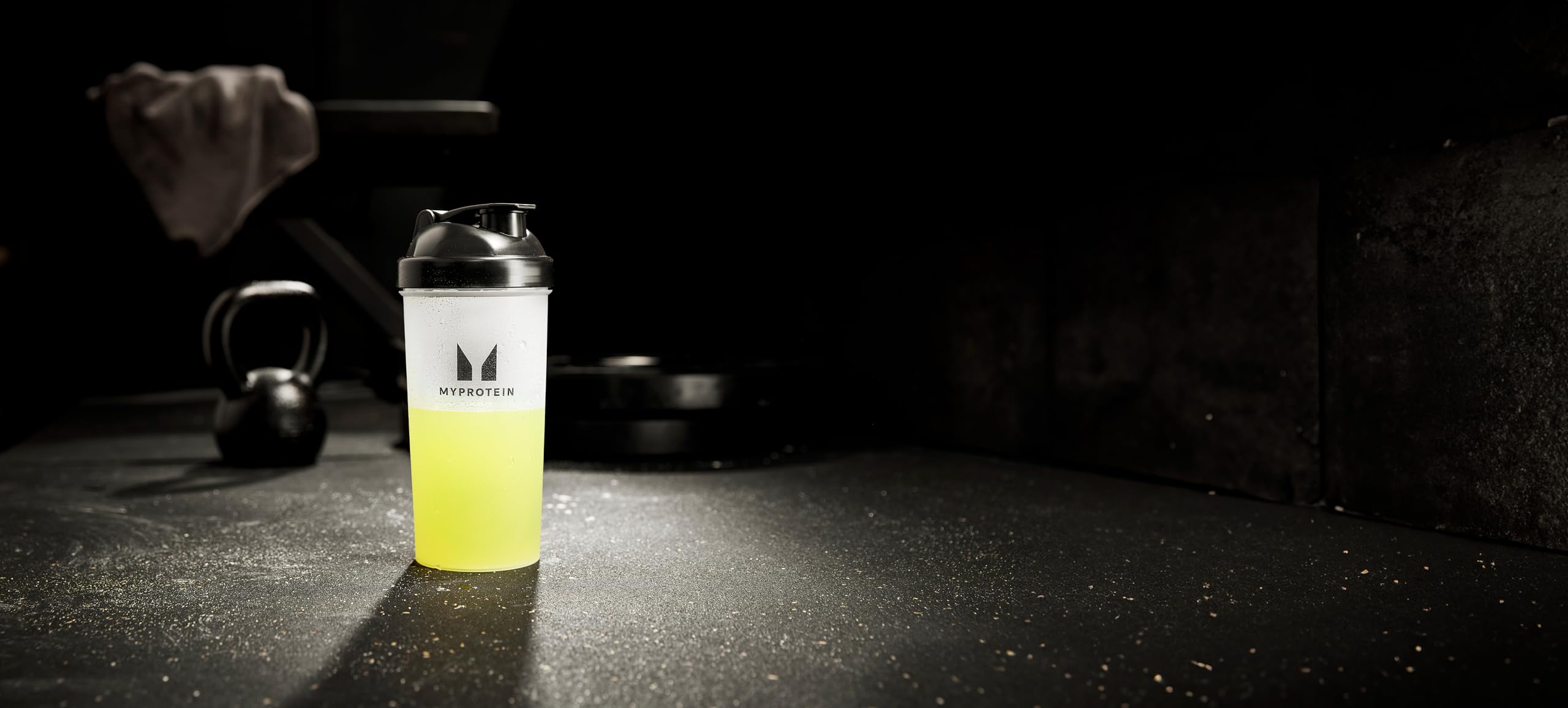 Lemon Lime flavor bottle beside water and sportswear for training