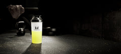 Lemon Lime flavor bottle beside water and sportswear for training