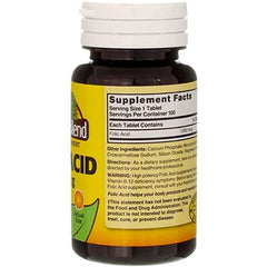 Nature's Blend Folic Acid bottle beside a glass of water for quick dosing.