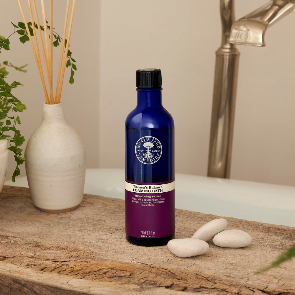 Hands applying Neal's Yard Remedies Women's Balance Massage Oil during a relaxing evening routine
