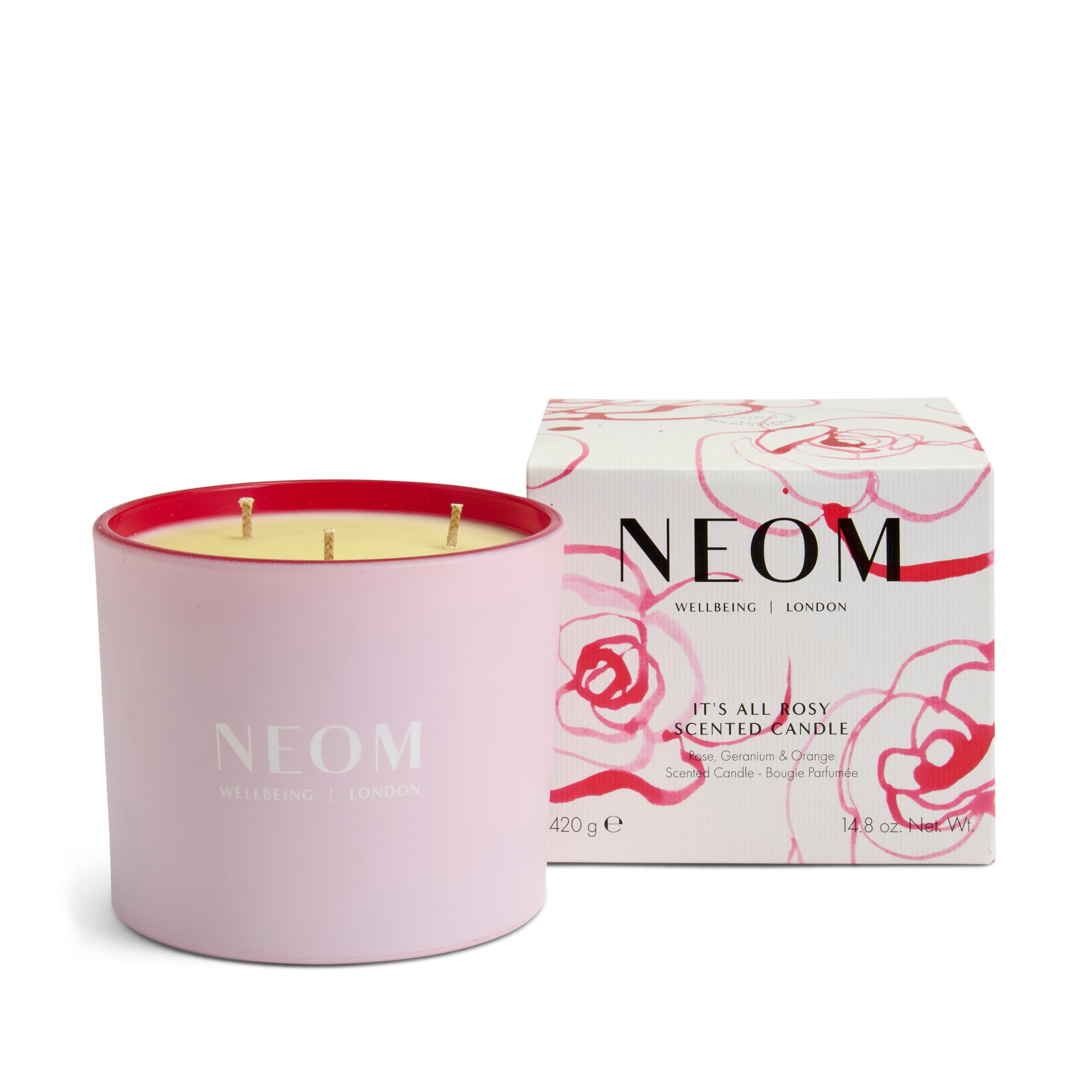 NEOM It's All Rosy Candle three-wick lit for warm ambiance.