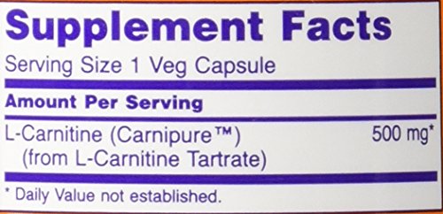 NOW Foods L-Carnitine 500 mg bottle beside gym gear suggesting fitness use.