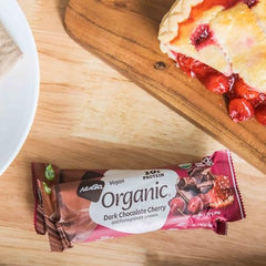 Close-up of NuGo bar reveals rich dark chocolate coating, ideal for vegan snacking.