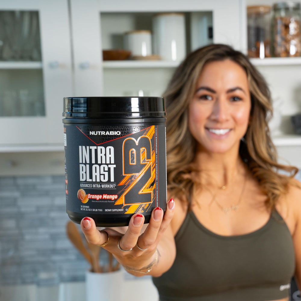 NutraBio Intra Blast Orange Mango powder dissolving in water for fast hydration and recovery.