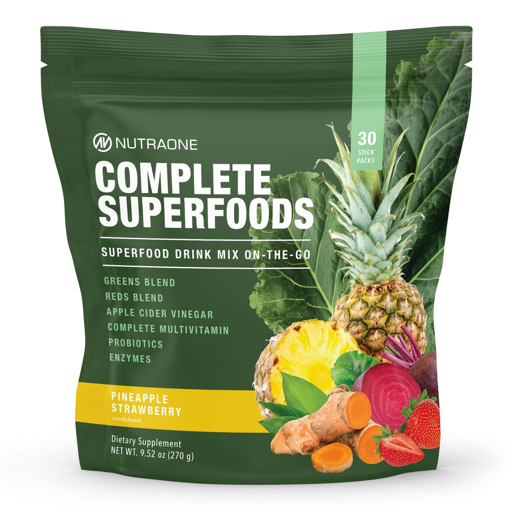 NutraOne Complete Superfoods pineapple-strawberry stick pack on a counter for daily nutrition.