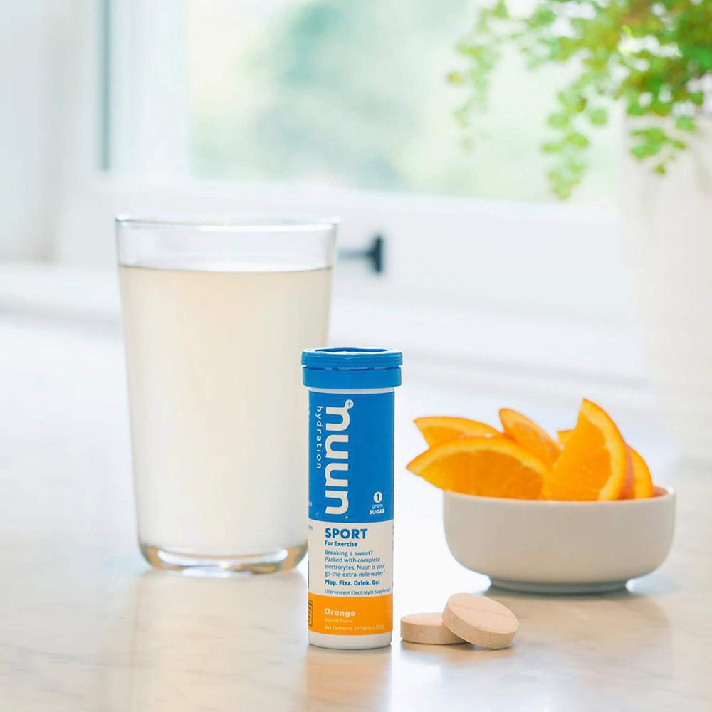 Glass with Nuun Sport Orange drink offering flavorful hydration after exercise.