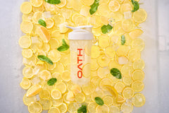 Oath Clear Whey Lemonade bottle beside sunny beach scene