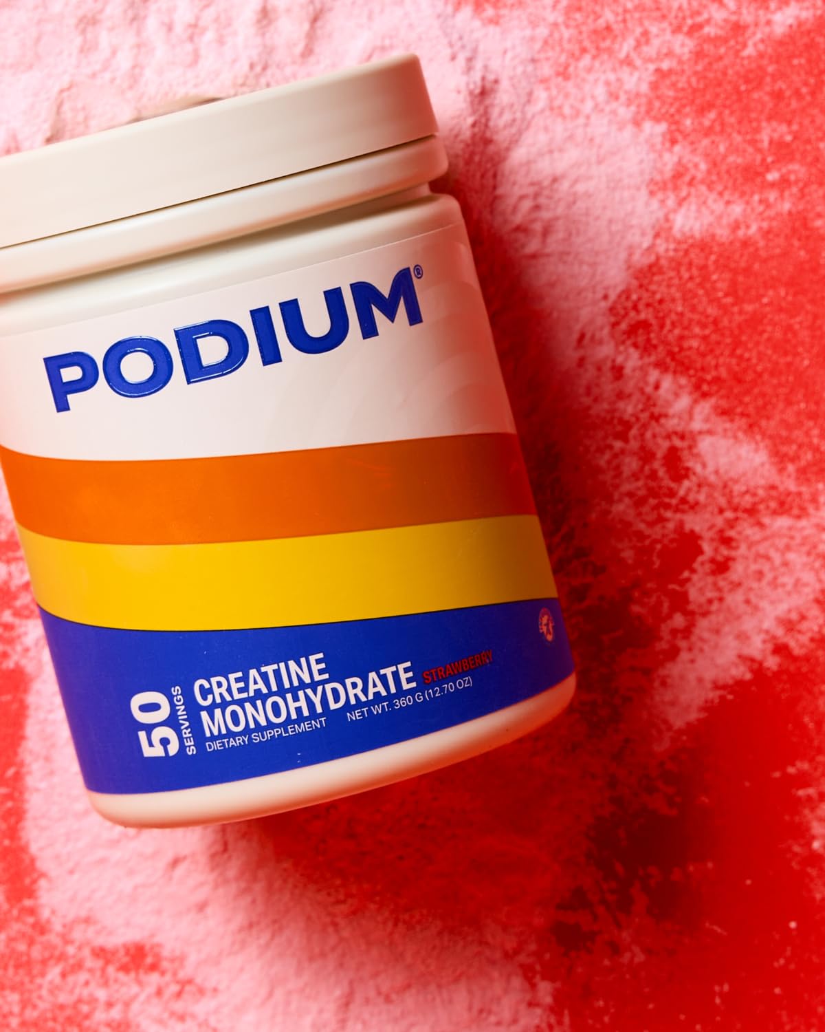 Podium Nutrition Solos creatine monohydrate pink lemonade powder being mixed in a glass.