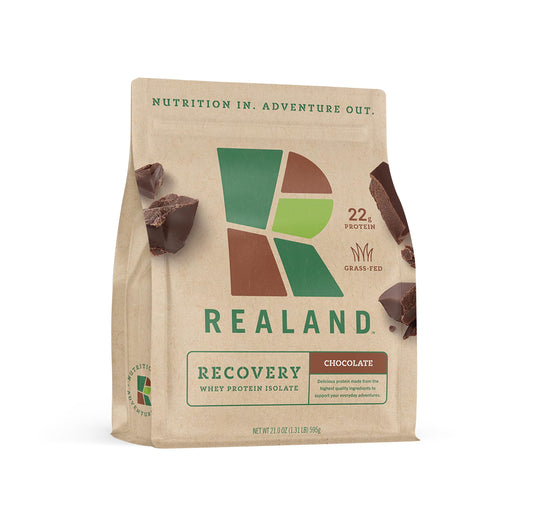 Realand Whey Isolate Chocolate bottle highlighting grass-fed protein for recovery