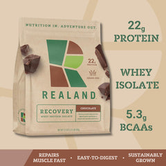 Realand chocolate whey powder scoop beside bottle for a post-workout shake
