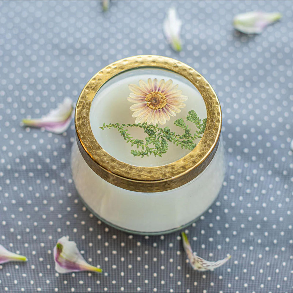 Pressed floral design on glass panels highlights the candle’s artistry while burning