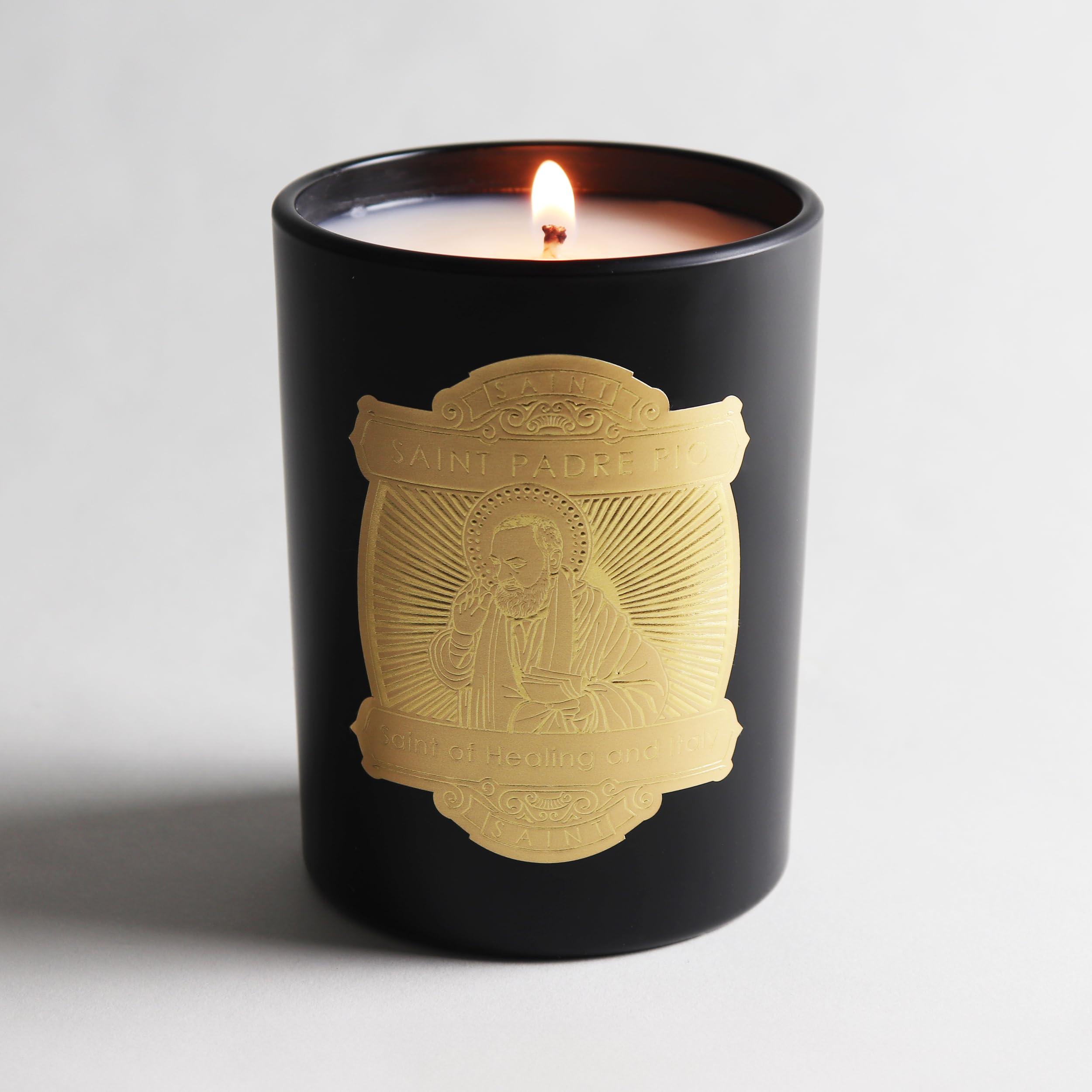 Saint Padre Pio Candle showing the Italian prayer coin embedded in wax.