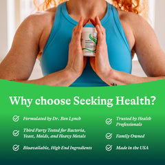 Seeking Health ProBiota HistaminX bottle beside a glass of water.