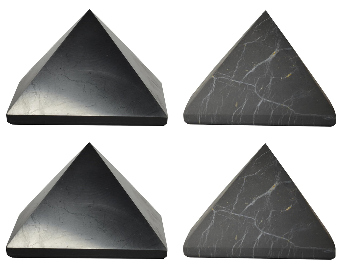 Shungite World polished pyramids 70mm on desk for focused energy protection.